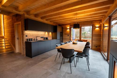 une cuisine et une salle à manger avec une table et des chaises dans l'établissement Chalet Les Cimes - Sauna - Jacuzzi, à Gérardmer