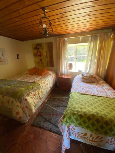 a bedroom with two beds and a window at Casa amplia con piscina y quincho in Concepción