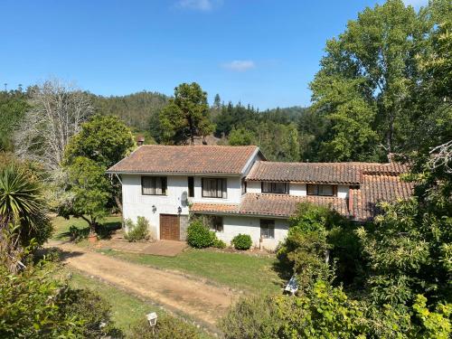 a large white house with red roof at Casa amplia con piscina y quincho in Concepción