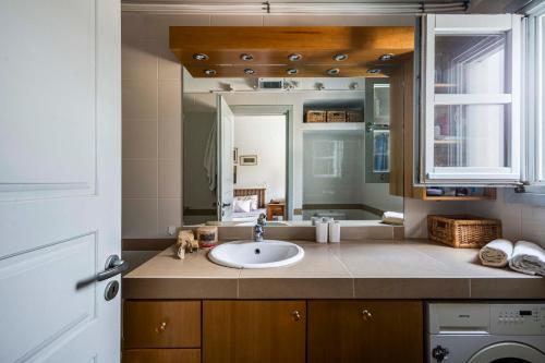 a bathroom with a sink and a mirror at Sandy Beachfront House Ganema Serifos in Ganema