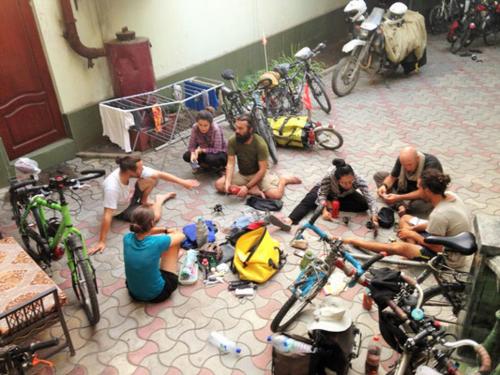 a group of people sitting on the floor with bikes at Green House Hostel in Dushanbe