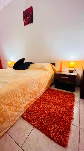 a bedroom with a bed with a red rug at Rita House Cozy Stay Near Malta Airport, Paola in Ħal Saflieni