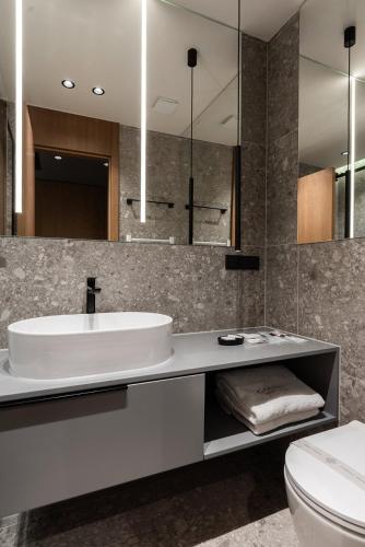 a bathroom with a sink and a toilet and a mirror at Garni Hotel Galeria in Banja Luka