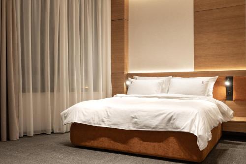 a bedroom with a large bed with white sheets and pillows at Garni Hotel Galeria in Banja Luka