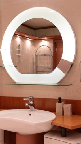 une salle de bain avec un lavabo blanc et un miroir dans l'établissement Black & White Suite & SPA - Sauna & Jacuzzi, à Gif-sur-Yvette