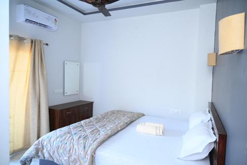 a small bedroom with a bed and a dresser at Dream Hampi Villa & Home Stay in Hampi