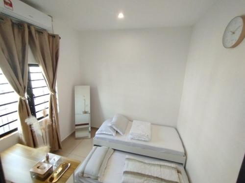 a small white room with a bed and a window at Golden Paradise in Kuantan