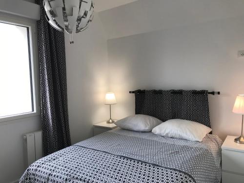 - une chambre avec un lit avec deux oreillers et une fenêtre dans l'établissement appart 3 chambres terrasse, à Le Touquet-Paris-Plage