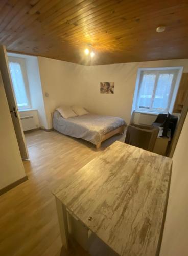 a bedroom with a bed and a wooden floor at La Halte de Massiac 1er étage in Massiac