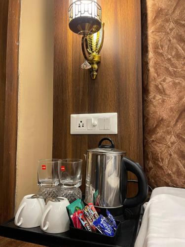a table with a blender and cups and a light at Hotel Zoon Dabb Srinagar airport kashmir in Srinagar