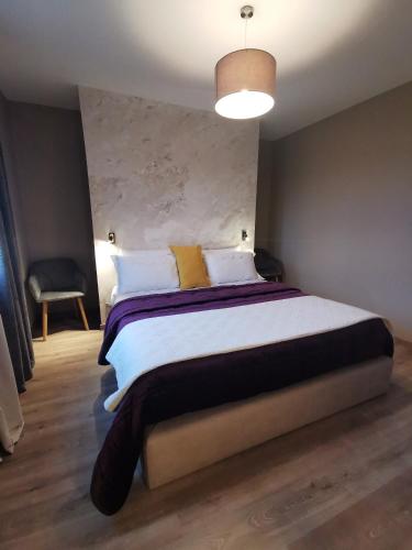 a bedroom with a large bed and a pendant light at A Flor da Rosa in Vila Nova de Foz Coa