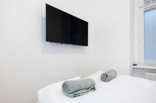 a white room with a tv and towels on a bed at Great 2-room apartment in Mitte in Berlin