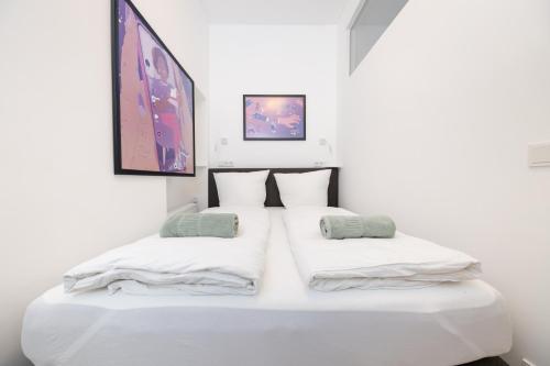 two beds in a room with white walls at Great 2-room apartment in Mitte in Berlin