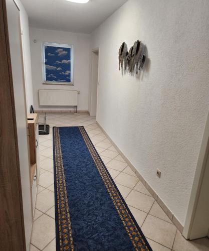 a hallway with a blue rug on the floor at SJ Apartment in Chemnitz