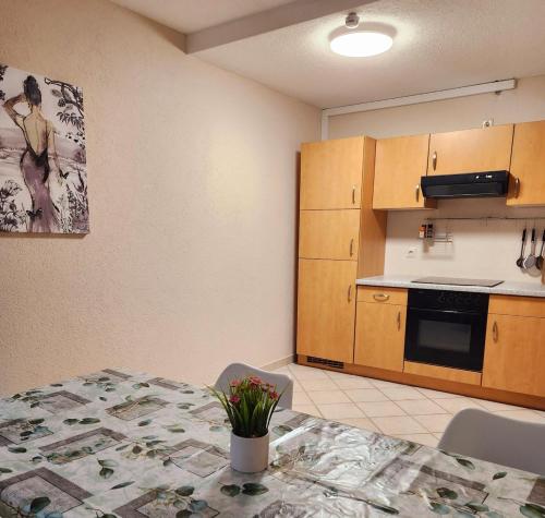 a kitchen with a table with a vase of flowers on it at SJ Apartment in Chemnitz