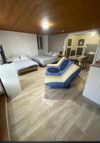 three beds in a room with a wooden floor at L’étape in Massiac