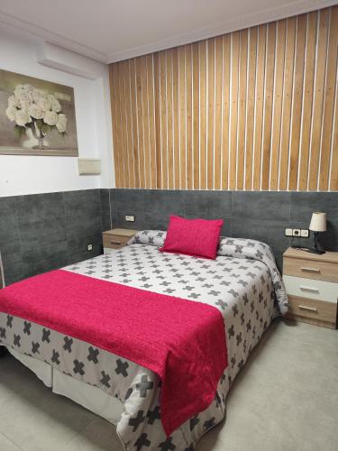 a bedroom with a large bed with a pink pillow at El LEGADO in Andújar