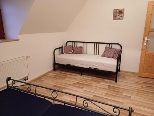 a bed in a room with a wooden floor at Chalupa U Kravína in Rtyně v Podkrkonoší