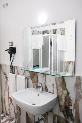 a bathroom with a sink and a mirror at Hotel Donatello in Modena