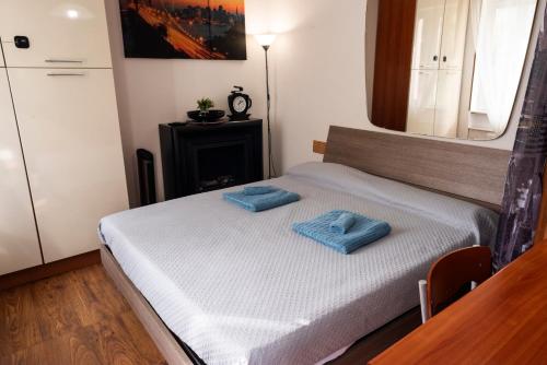 Un dormitorio con una cama con dos toallas azules encima. en Vista Lago-Appartamento Giardino dell'Eden, en Ghirla