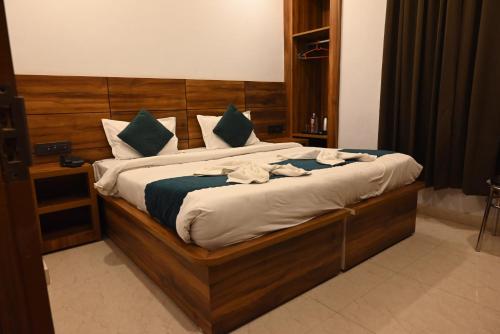 a bedroom with a large bed with a wooden headboard at Hotel Vaidik Ganga in Rishīkesh