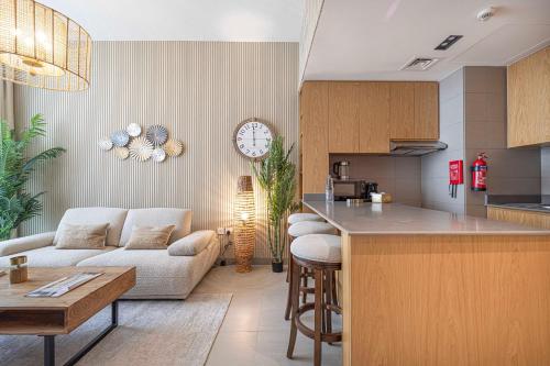 una cucina e un soggiorno con divano e tavolo di 1BR The Monarch Suite by Blue Cloud Holidays a Sharjah