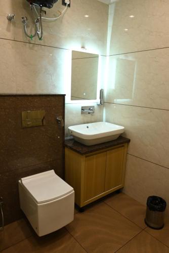 a bathroom with a sink and a toilet and a mirror at Hotel Vaidik Ganga in Rishīkesh