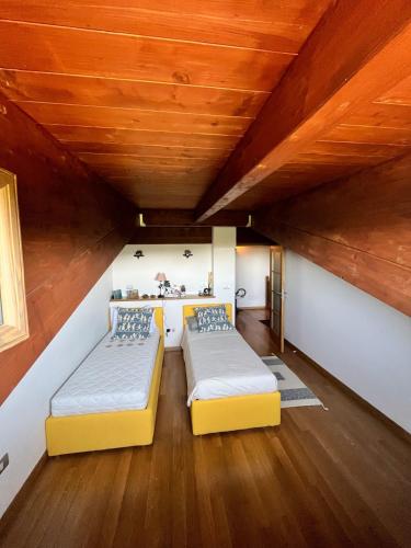 two beds in a room with a wooden ceiling at Splendido Chalet in Camigliatello Silano