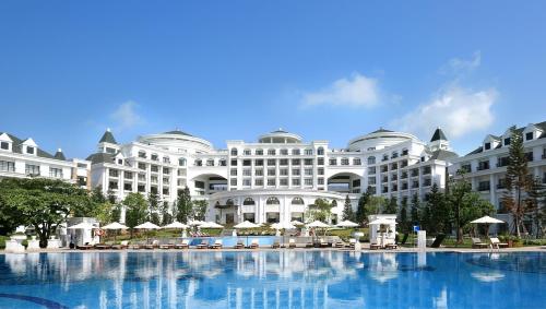 a large white building with a large swimming pool at Vinpearl Resort & Spa Ha Long in Ha Long