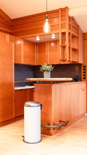 une cuisine avec des placards en bois et une poubelle dans l'établissement Premium Spa Chalet - Sauna & Jacuzzi - 20min Paris, à Gif-sur-Yvette