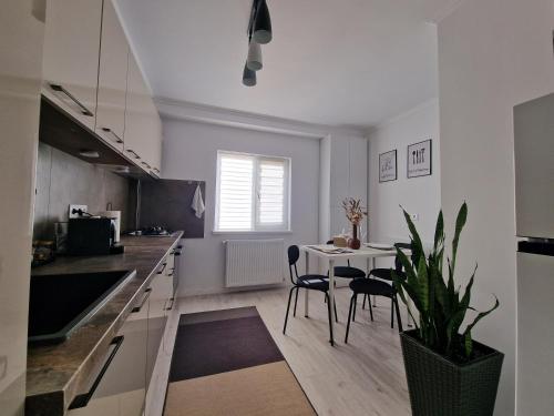 Una cocina con una mesa y un comedor. en Elite Apartment Onesti, en Onești