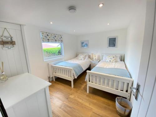 a bedroom with two beds and a window at Two Bed Chalet with Sea Views in Antony