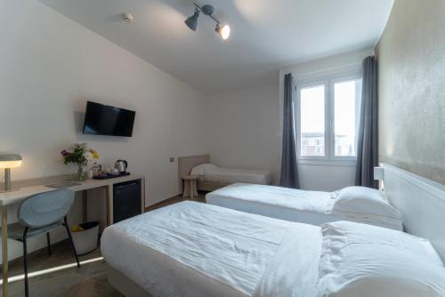 a hotel room with two beds and a desk and a window at Hotel Donatello in Modena