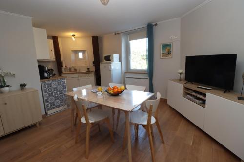 une cuisine avec une table avec un bol de fruits dessus dans l'établissement L'Océan by Tranquil at Home, à Pornichet