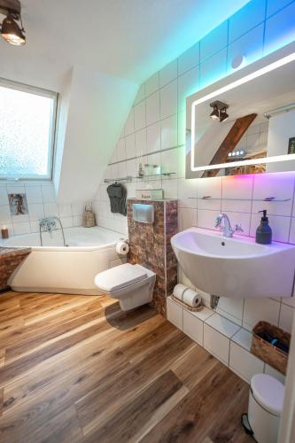 a bathroom with a sink and a tub and a toilet at Design Loft mit Whirlpool - Einzigartig & Citynah in Krefeld