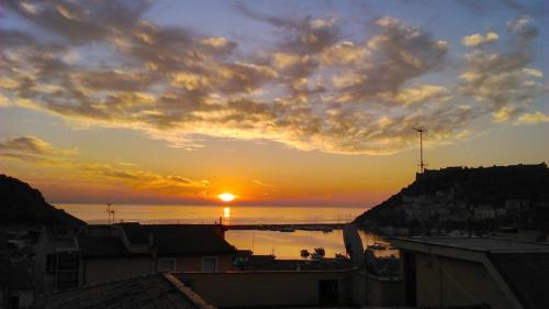 a sunset over the ocean with the sun in the sky at Alba sul Mare in Porto Ercole