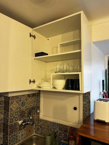 a kitchen with white cabinets and a sink at Cantinho das Portas do Sol II in Lisbon