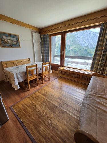 un salon avec une table et une grande fenêtre dans l'établissement BEC 562 - Beautiful apt 4pers - Tignes le Lac, à Tignes