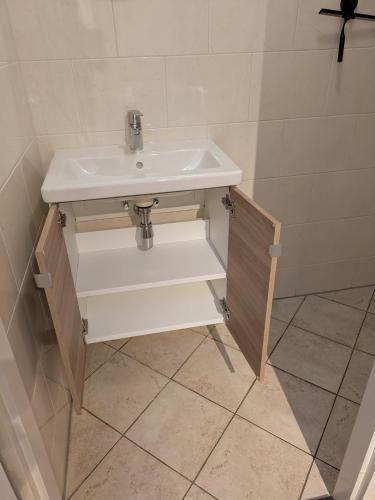 a bathroom with a sink and some shelves at Logies21 Texel in Oosterend