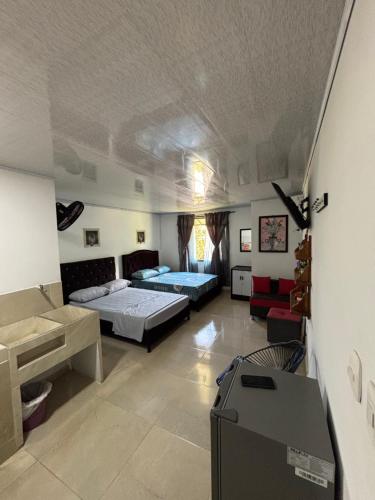 a bedroom with two beds and a desk in it at Habitación la esmeralda in Puerto Triunfo