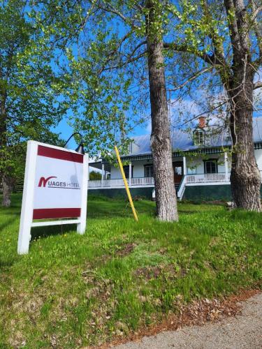 a sign in the grass in front of a house at Auberge des Nuages in La Malbaie