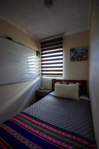 a small bedroom with a bed and a window at Hermosa vista laguna tres Pascualas in Concepción