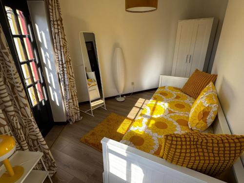 a bedroom with a bed with a yellow and white comforter at Refúgio da Nazaré Alojamento Local Veloso in Valado dos Frades