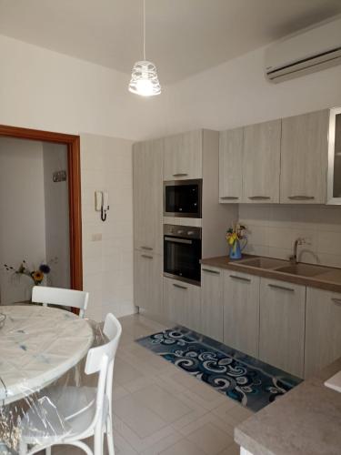 a kitchen with a table and a dining room at Appartamento Marco a pochi passi dal mare S.Vito in San Vito lo Capo