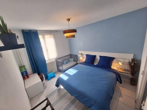 a bedroom with a blue bed and a blue wall at Appartement central avec parking in Carcassone