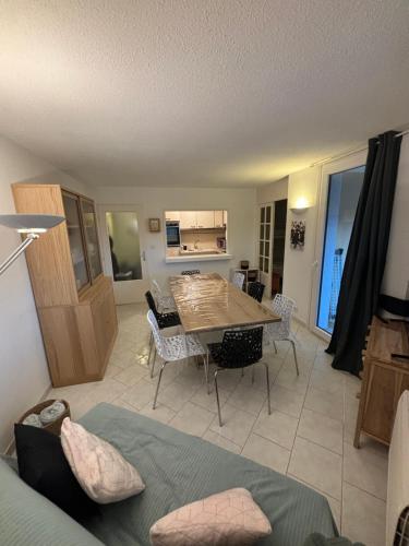 un salon avec une table et une salle à manger dans l'établissement le balcon de Funès, proche des plages, à Fréjus