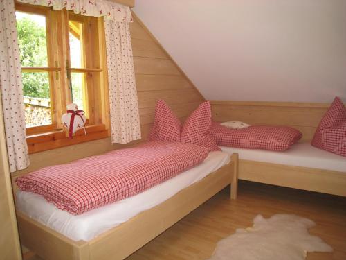 Habitación pequeña con 2 camas y ventana en Ferienhütte Wolfgangsee en St. Wolfgang