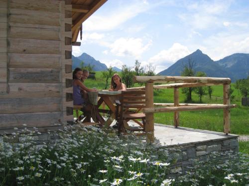 three women sitting at a table outside of a cabin at Ferienhof Brunbacher Wolfgangsee in St. Wolfgang