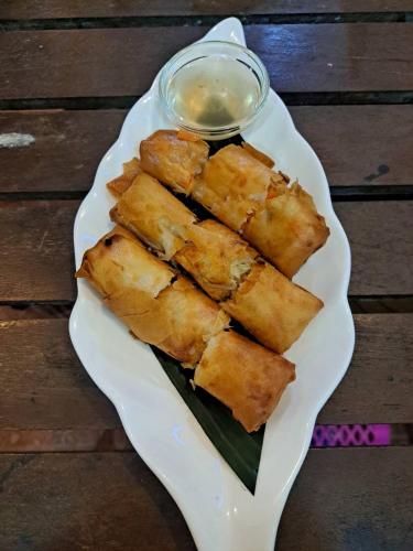 a plate of food on a table with sauce at Sunny Cove Beach Resort Koh Phayam in Ranong