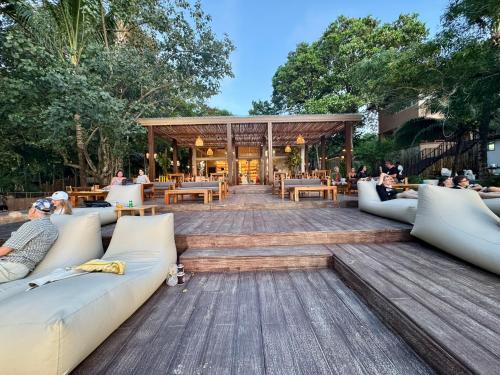 a patio with couches and tables and people sitting at Sunny Cove Beach Resort Koh Phayam in Ranong